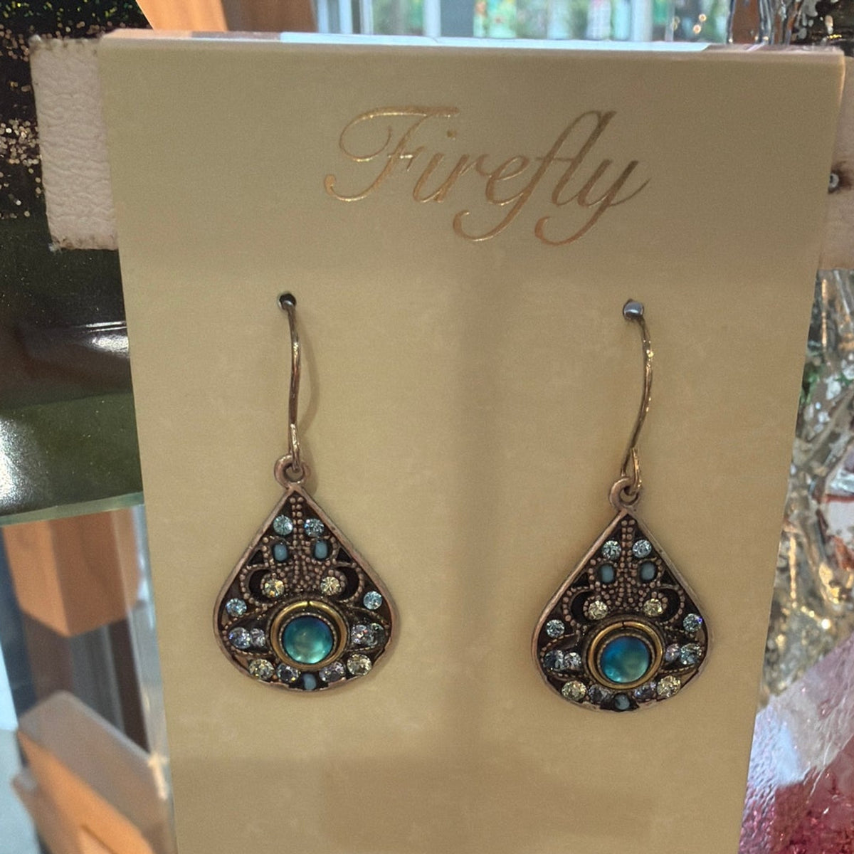 Antiqued teardrop earrings with aqua center stone and blue crystals on a Firefly card