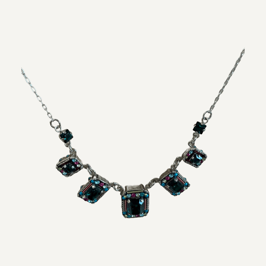 Close-up of emerald crystal settings edged with turquoise and pink crystals