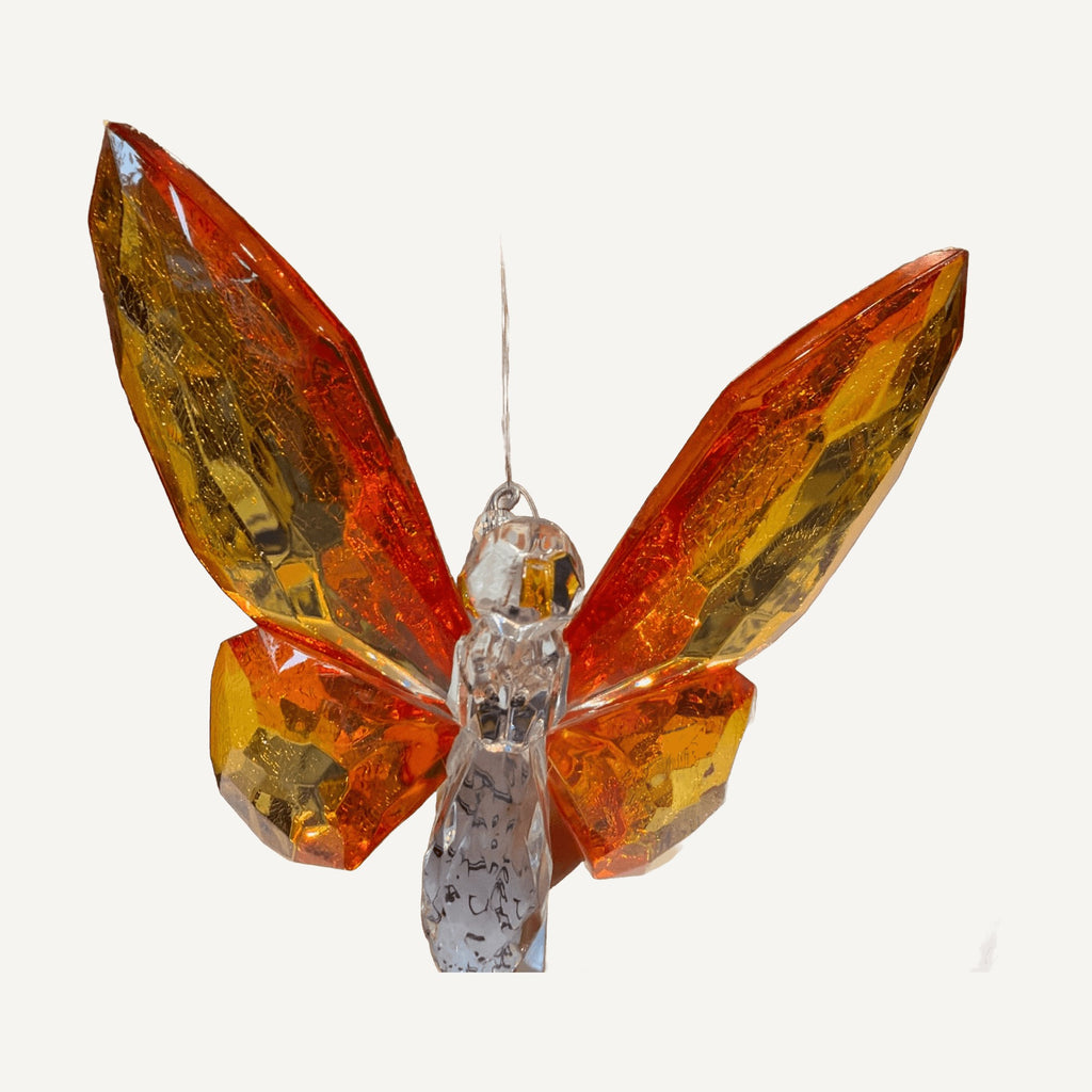 Orange and amber faceted crystal butterfly hanging from a black stand