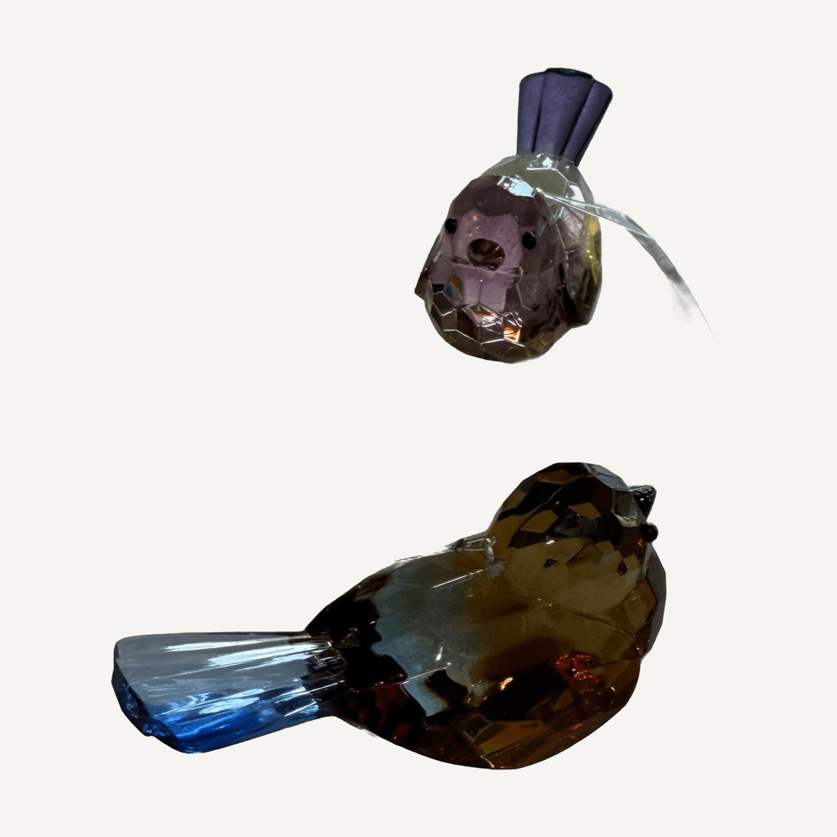 Blue and purple faceted crystal songbirds side by side