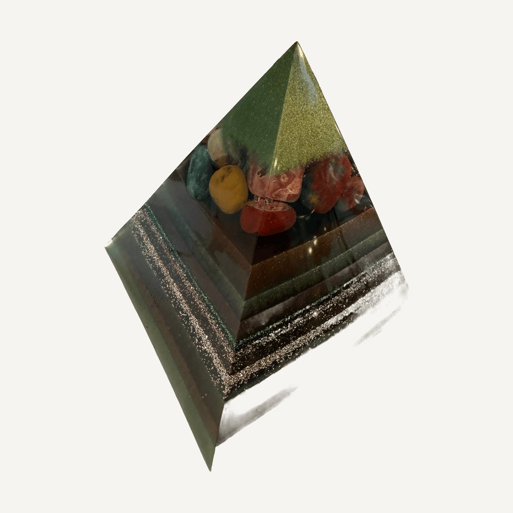 Angled view of green resin pyramid with red, yellow and teal tumbled stones