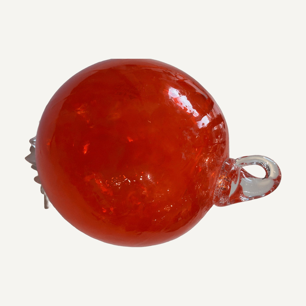 Orange glass ball ornament with a clear glass hanging loop