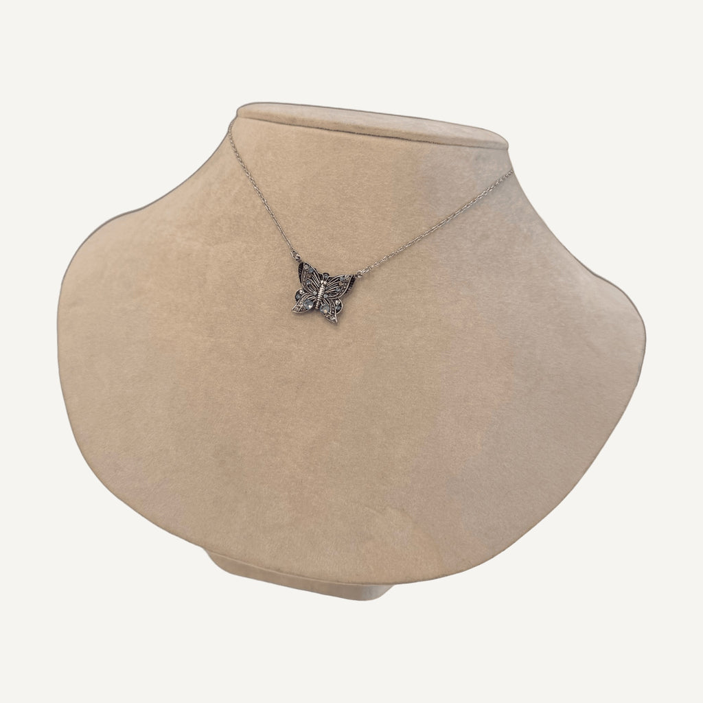 Crystal butterfly necklace on a beige velvet bust