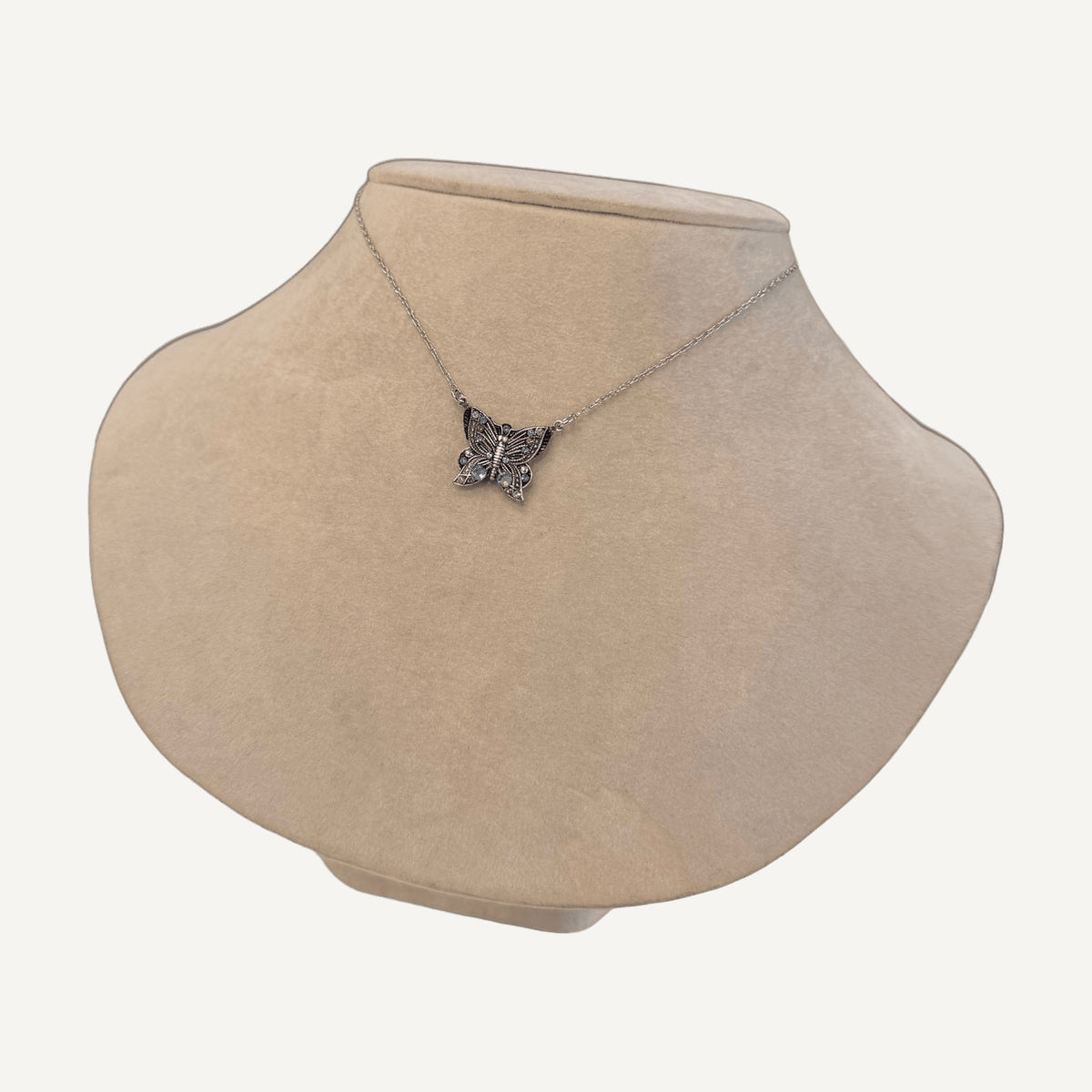 Crystal butterfly necklace on a beige velvet bust