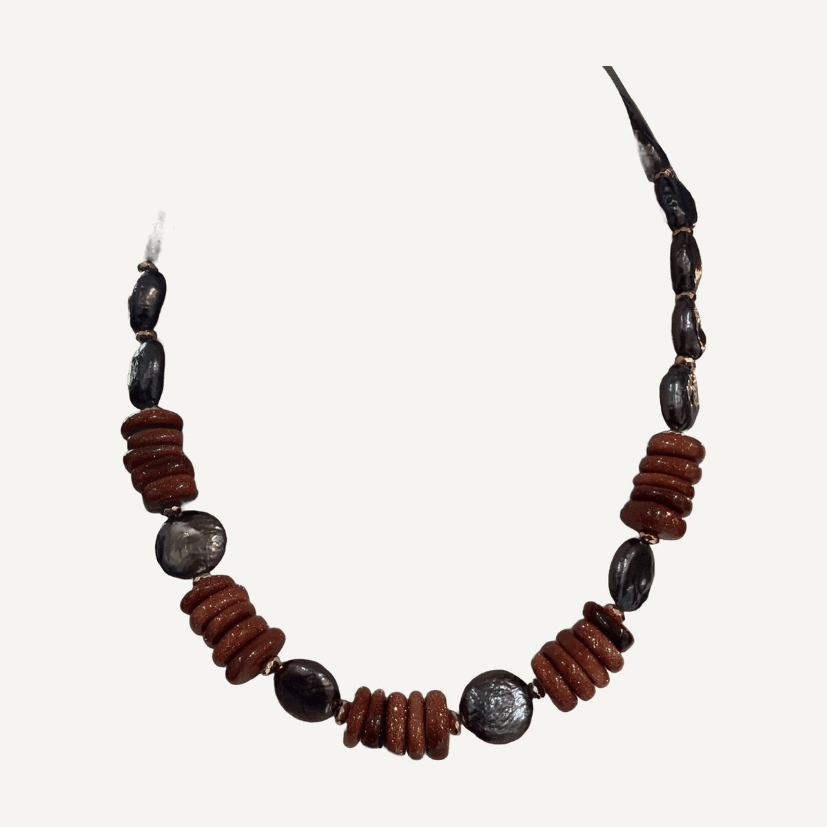 Purple coin pearl and copper goldstone rondelle necklace on a cream bust